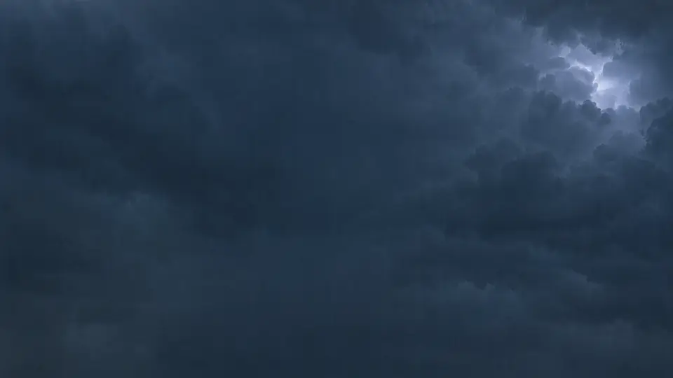 Dark slate storm clouds with a flash of light breaking through.